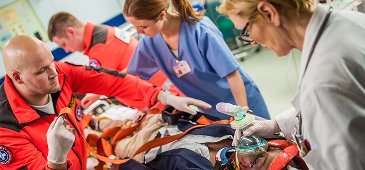 nurse and paramedics working together with injured patient on gurney