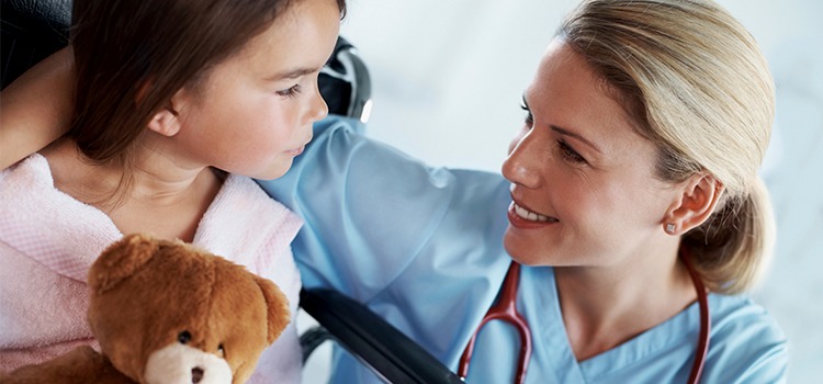 nurse with young patient holding teddy bear