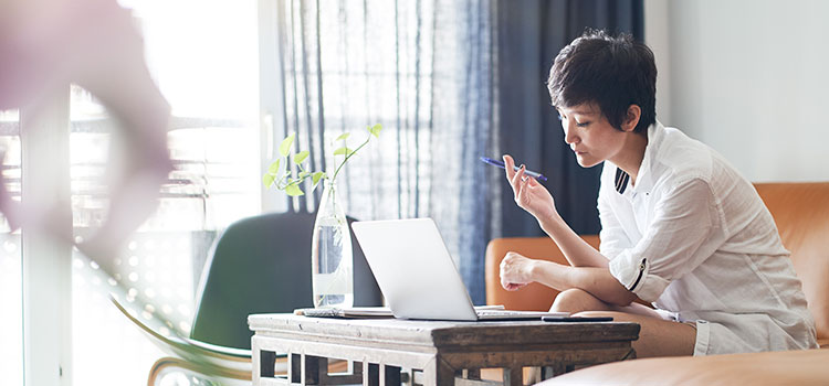 woman looks at laptop to review online education programs