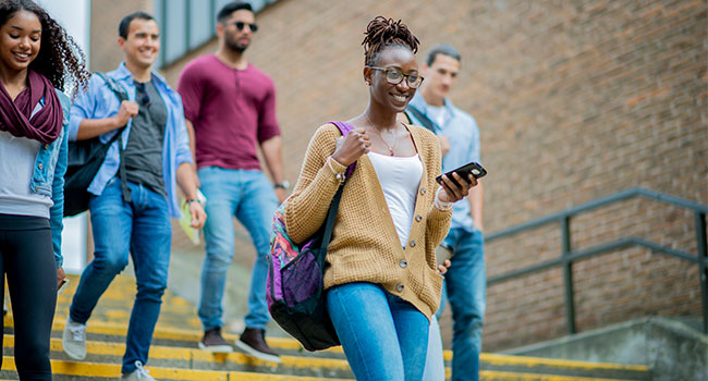 diverse group of college students walking down stairs