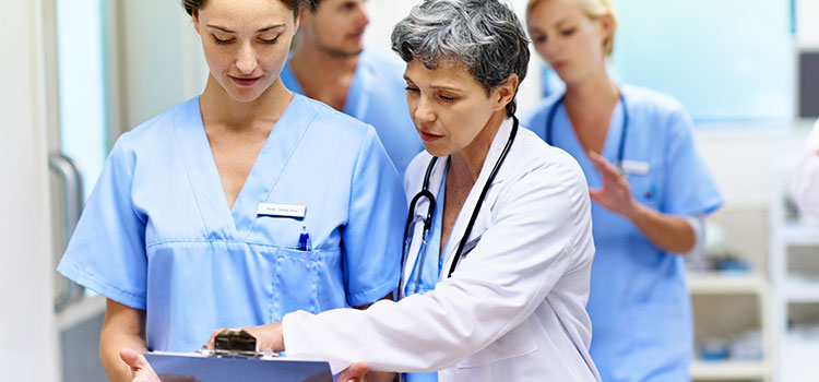 nurse confers with staff on ward