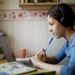 woman taking class online wearing headphones