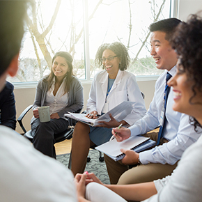 smiling and diverse group of nurses in meeting