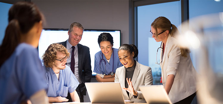 woman healthcare administrator meets with team of nurses and leaders