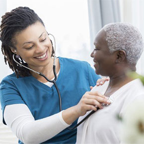 young female nurse takes older patients vital signs