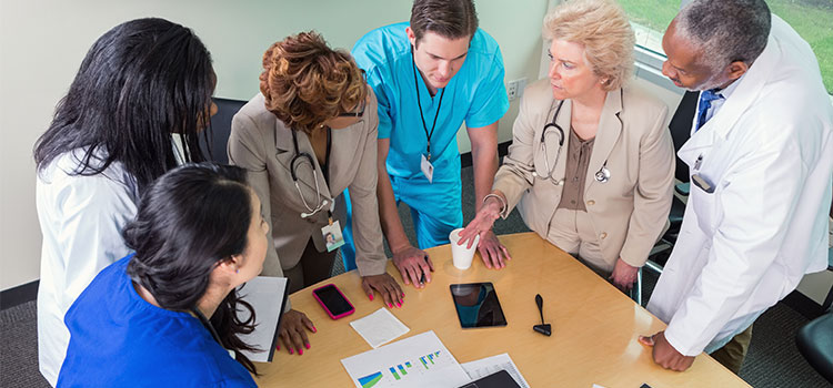 medical staff standing at table in discussion