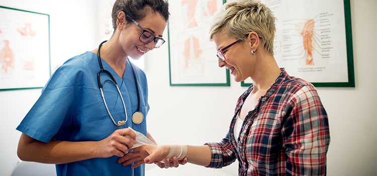dermatology nurse putting bandage on patients wrist