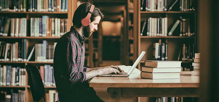 profile of man sitting in library studying