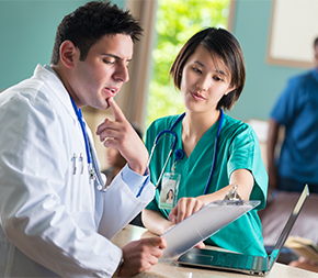 nurse reviews medical chart with doctor