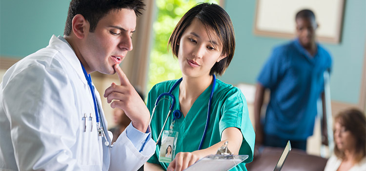 nurse reviews medical chart with doctor