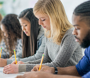students taking test with yellow pencils