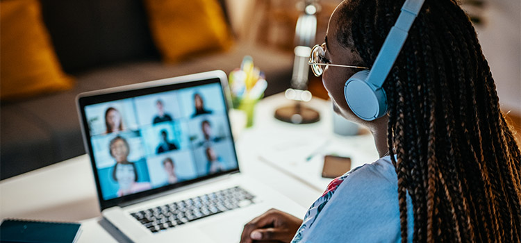 student wearing headphones on laptop conference call