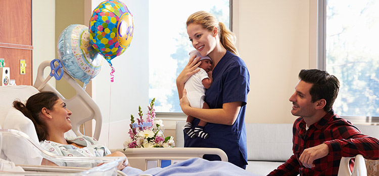 labor and delivery nurse holding newborn baby
