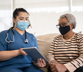 nurse visits elder patient in casual setting