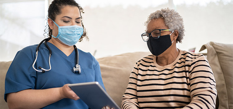 nurse visits elder patient in casual setting