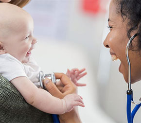 midwife smiling with newborn infant