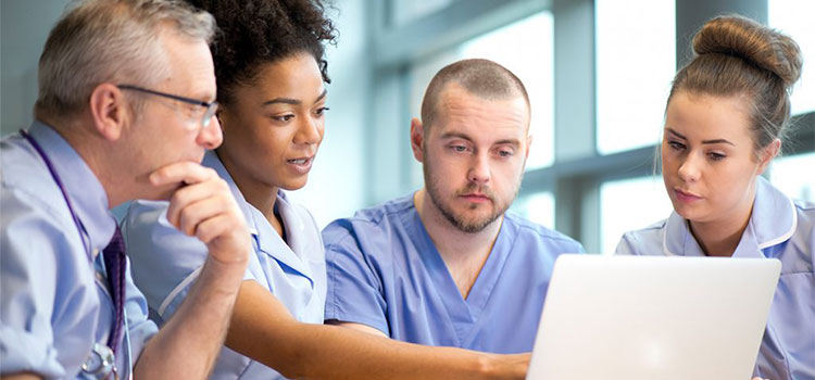 nurses looking at laptop computer in meeting