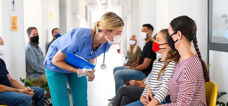 public health nurse greeting girl patient in hallways