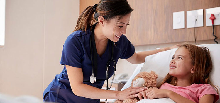 smiling nurse with child patient in hospital room