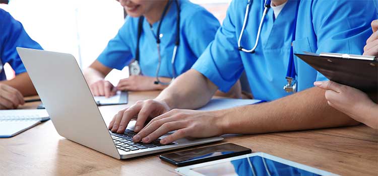 nurses in class hands typing on laptop keyboard