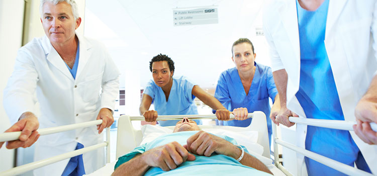 emergency room medical team wheeling patient down hallway