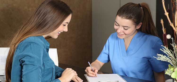 nurse registers patient at check in desk