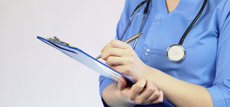 nurse hand adding notes to chart