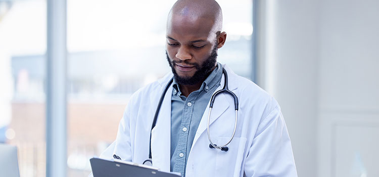male nurse records patient vitals on chart