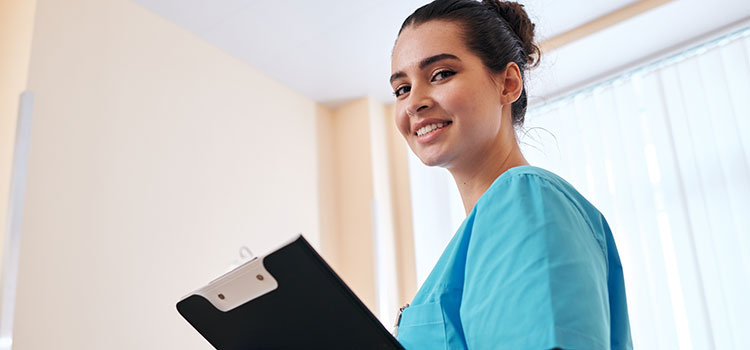 licensed nurse holds clipboard and makes rounds