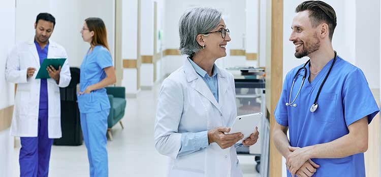 nurse manager talks with male nurse in hospital wing