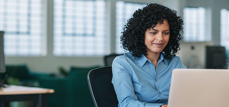 woman searches online on a laptop while seated