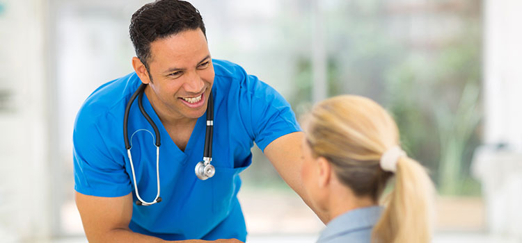male nurse shakes hands with female patient in wheelchair