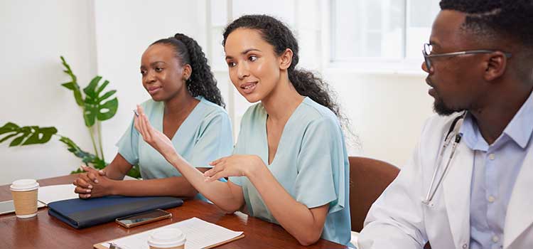 women nurses review claim file with male doctor and off camera administrator