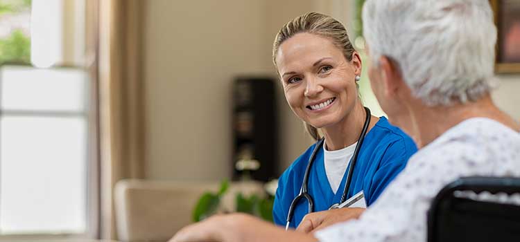 female adult gerontology nurse practitioner talks with male senior patient