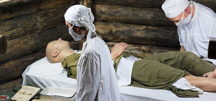 military medic staff work on soldier in rustic setting