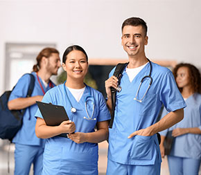 nursing students stand and smile in a university hallway